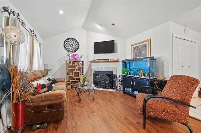 3217 Whatley Dr, Garland, TX 75043 - living room with wood finished floors, lofted ceiling, a tiled fireplace, and recessed lighting
