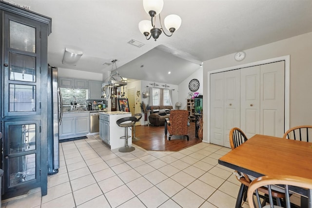 3217 Whatley Dr, Garland, TX 75043 - kitchen featuring light countertops, light tile patterned floors, stainless steel appliances, vaulted ceiling, and gray cabinetry