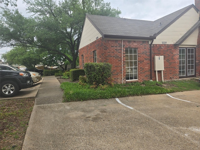 3217 Whatley Dr, Garland, TX 75043 - view of side of property featuring brick siding and uncovered parking
