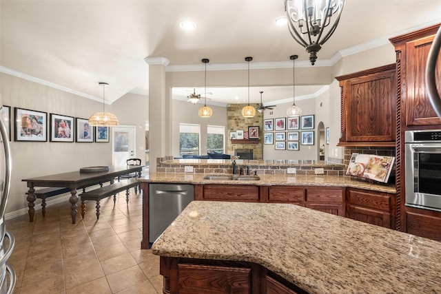 kitchen with decorative light fixtures, crown molding, light tile patterned floors, light stone counters, and stainless steel appliances