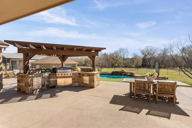 view of patio featuring a fenced in pool, fence, grilling area, and an outdoor kitchen