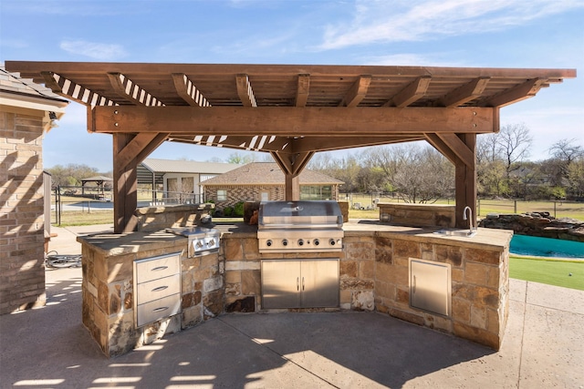 view of patio with a sink, exterior kitchen, and grilling area