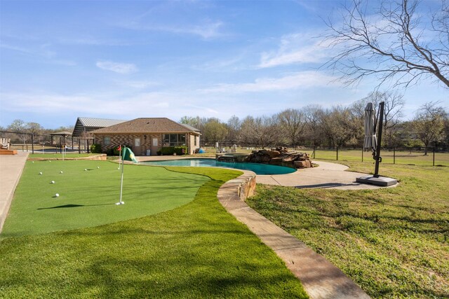 view of property's community with fence, a swimming pool, a lawn, and a patio area