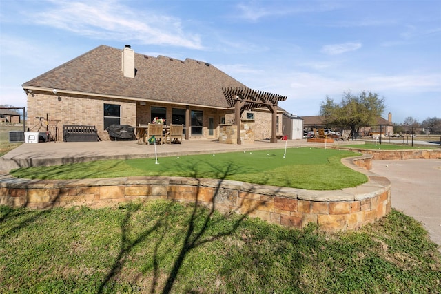 rear view of property featuring a chimney, a patio area, brick siding, a pergola, and a shingled roof