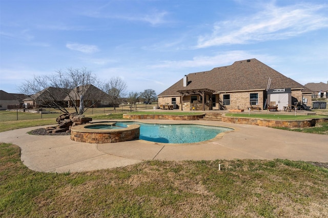 view of pool featuring a lawn, a pool with connected hot tub, fence, and a patio area