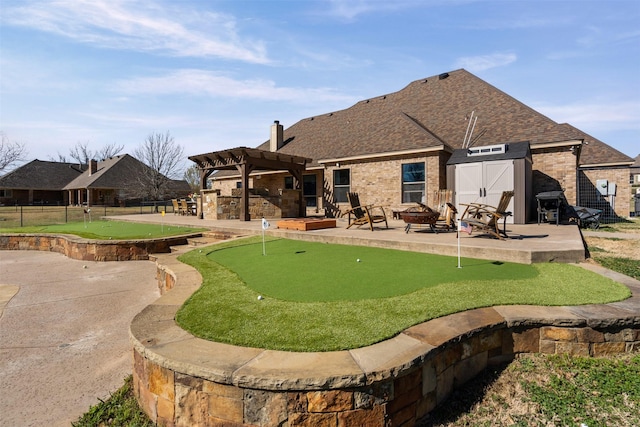 back of house with a patio, an outdoor fire pit, a pergola, and brick siding