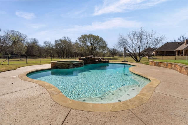 view of swimming pool featuring a lawn, a pool with connected hot tub, fence, and a patio area