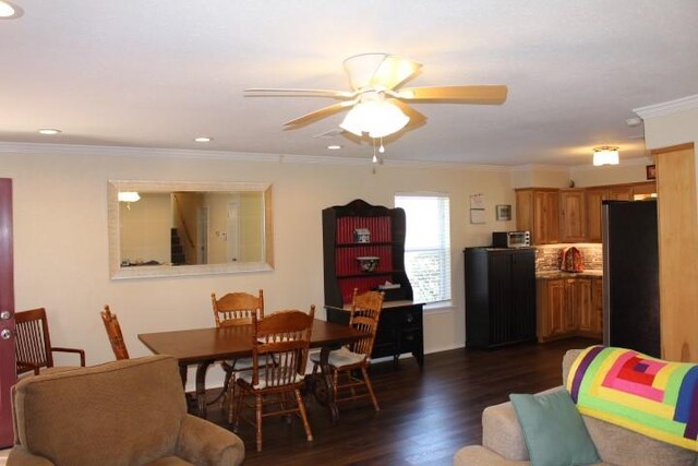 dining space with crown molding, ceiling fan, and dark wood finished floors