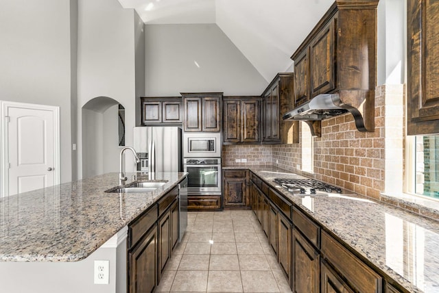 7813 Saint Clair Dr, Mckinney, TX 75071 - kitchen featuring stainless steel appliances, decorative backsplash, a sink, arched walkways, and light stone countertops