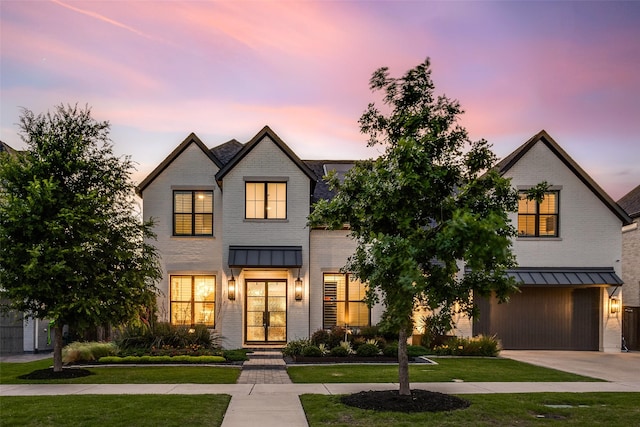 6023 Manderlay Dr, Frisco, TX 75034 - view of front facade with brick siding, a standing seam roof, an attached garage, and a front lawn