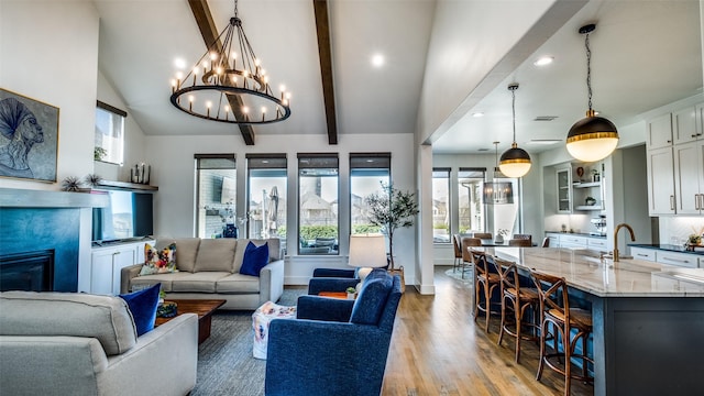 6023 Manderlay Dr, Frisco, TX 75034 - living room featuring plenty of natural light, light wood finished floors, recessed lighting, a chandelier, and a glass covered fireplace