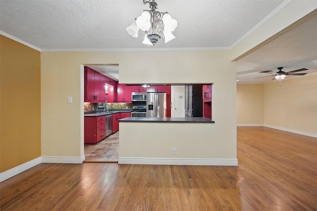 kitchen featuring dark countertops, wood finished floors, and appliances with stainless steel finishes
