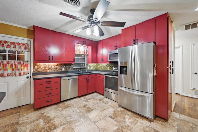 kitchen with red cabinets, tasteful backsplash, dark countertops, and stainless steel appliances
