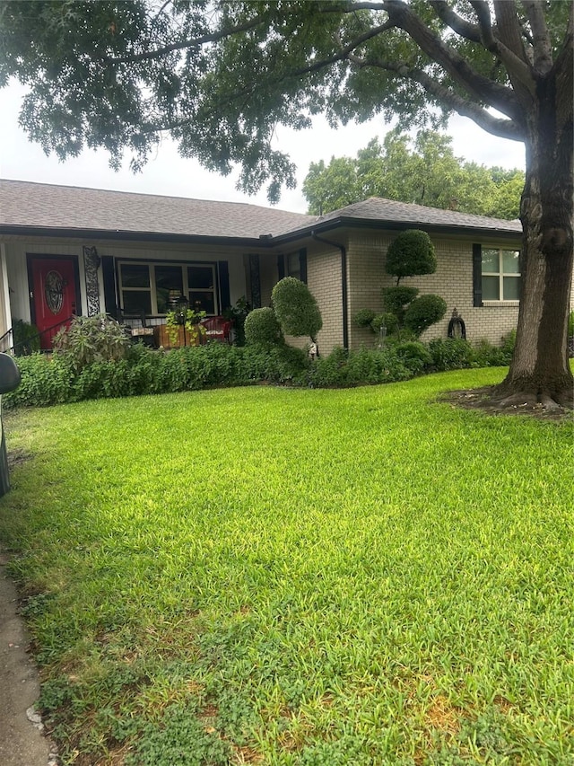 single story home featuring a front lawn and brick siding