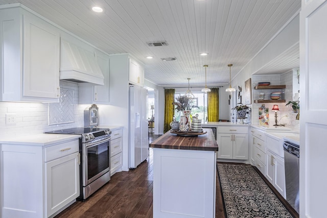 1125 Old Airport Rd, Weatherford, TX 76087 - kitchen with open shelves, butcher block countertops, appliances with stainless steel finishes, custom exhaust hood, and visible vents
