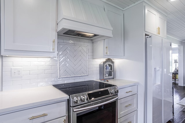 1125 Old Airport Rd, Weatherford, TX 76087 - kitchen with light countertops, white refrigerator with ice dispenser, white cabinetry, custom range hood, and stainless steel electric range oven
