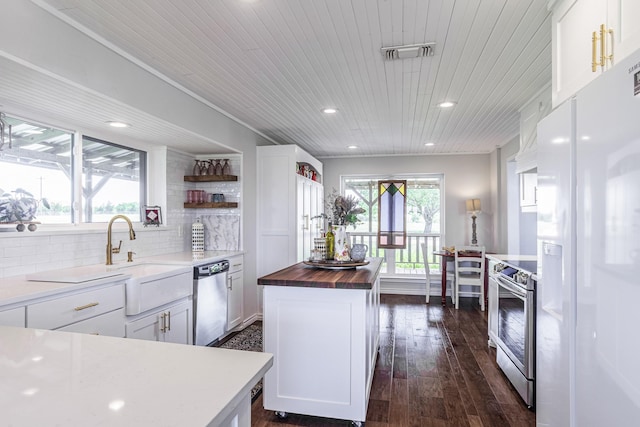 1125 Old Airport Rd, Weatherford, TX 76087 - kitchen with open shelves, white cabinetry, butcher block countertops, appliances with stainless steel finishes, and visible vents