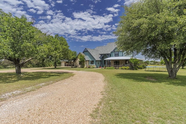 1125 Old Airport Rd, Weatherford, TX 76087 - view of front facade featuring a trampoline, stone siding, a front yard, and curved driveway