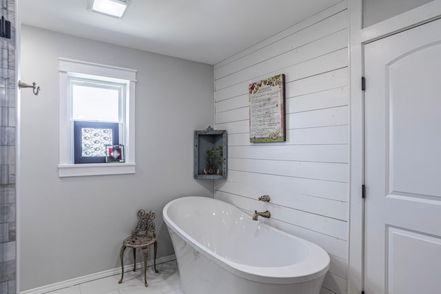 1125 Old Airport Rd, Weatherford, TX 76087 - bathroom with baseboards, marble finish floor, wood walls, and a soaking tub