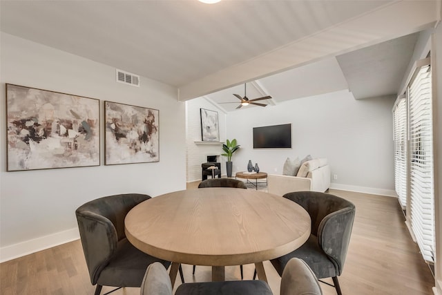 dining room with light wood-type flooring, a ceiling fan, and baseboards