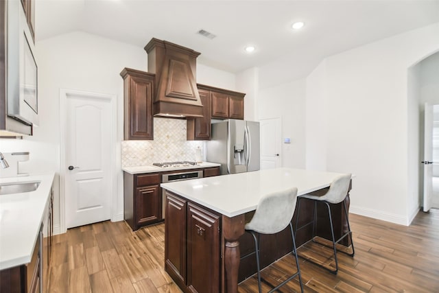1236 Arrowwood Dr, Aubrey, TX 76227 - kitchen with light countertops, custom range hood, a center island, visible vents, and appliances with stainless steel finishes