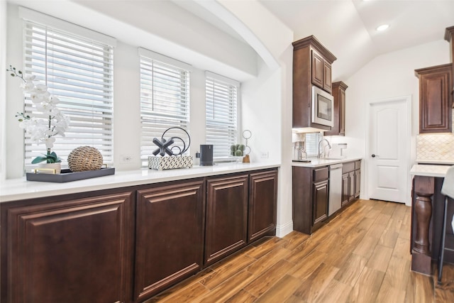 1236 Arrowwood Dr, Aubrey, TX 76227 - kitchen with light countertops, vaulted ceiling, stainless steel appliances, a sink, and wood finished floors