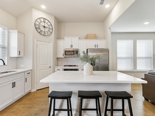 5024 Wilder Ave, Celina, TX 76227 - kitchen featuring appliances with stainless steel finishes, a kitchen bar, backsplash, a sink, and recessed lighting
