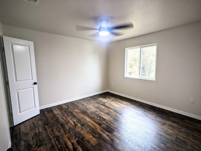 empty room featuring dark wood-style floors, baseboards, and ceiling fan