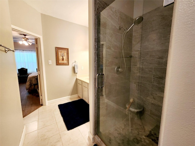full bathroom with ensuite bathroom, vanity, baseboards, a stall shower, and a ceiling fan