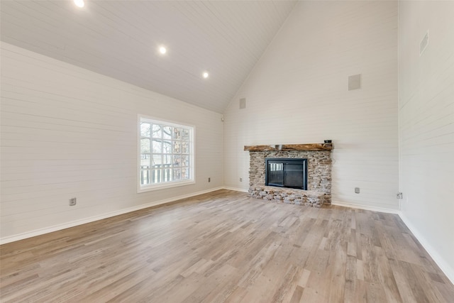 unfurnished living room featuring baseboards, a fireplace, high vaulted ceiling, and wood finished floors