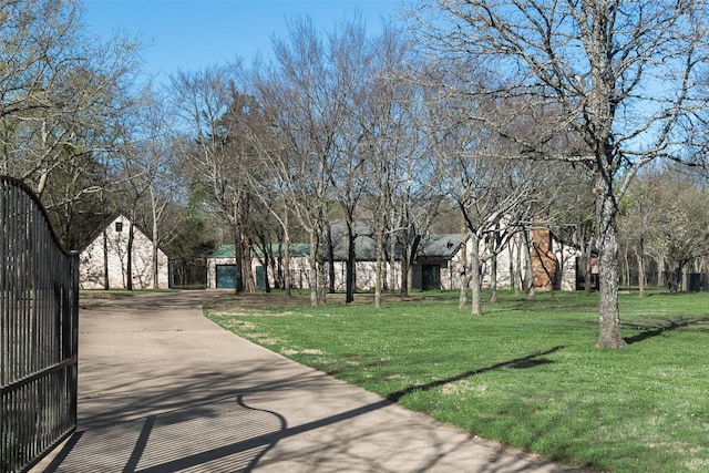 view of community featuring a lawn, driveway, and a garage
