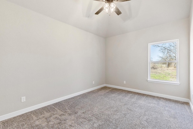 carpeted spare room with baseboards and a ceiling fan