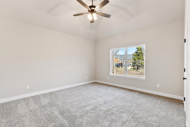 spare room with baseboards, a ceiling fan, vaulted ceiling, and carpet floors