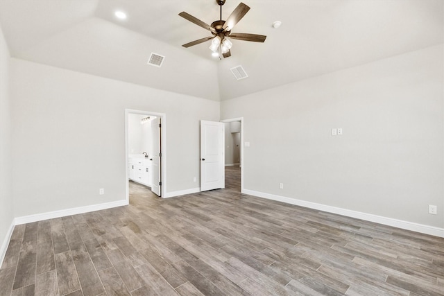 unfurnished bedroom with wood finished floors, high vaulted ceiling, and visible vents