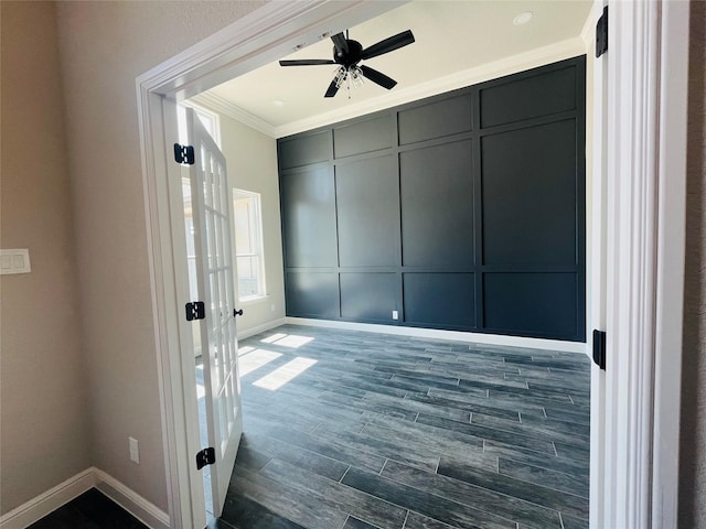 spare room featuring baseboards, ornamental molding, and ceiling fan