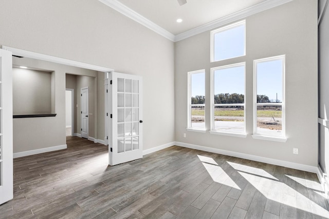 unfurnished room featuring a towering ceiling, baseboards, and ornamental molding