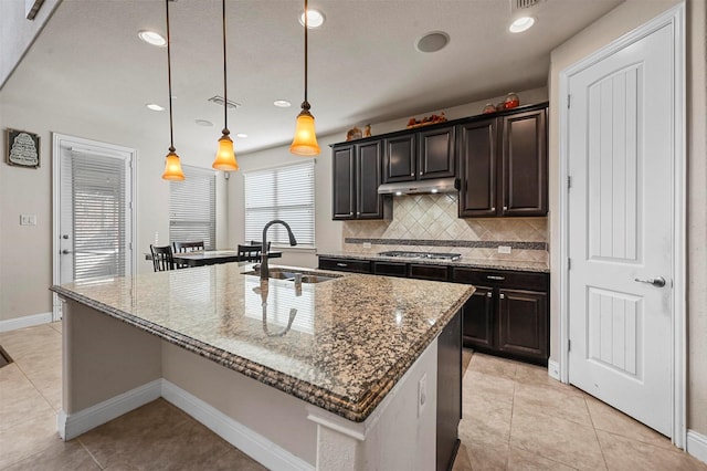 1216 Sioux St, Carrollton, TX 75010 - kitchen featuring a sink, stainless steel gas cooktop, stone countertops, an island with sink, and recessed lighting