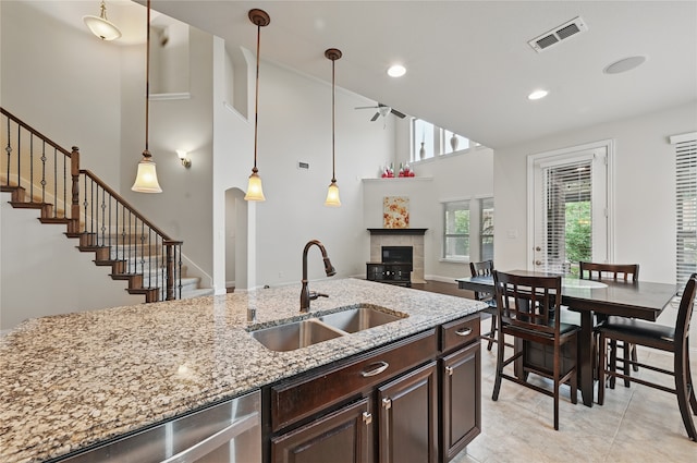 1216 Sioux St, Carrollton, TX 75010 - kitchen featuring a sink, ceiling fan, dark brown cabinetry, stainless steel dishwasher, and light stone countertops