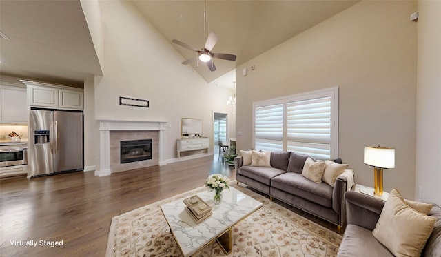1051 Copper Canyon Dr, Prosper, TX 75078 - living room with high vaulted ceiling, dark wood-type flooring, a tile fireplace, ceiling fan, and baseboards