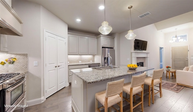 1051 Copper Canyon Dr, Prosper, TX 75078 - kitchen with stainless steel appliances, a sink, backsplash, wood-type flooring, and premium range hood