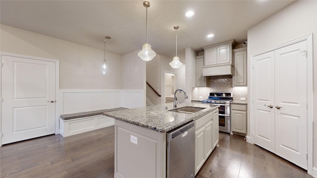 1051 Copper Canyon Dr, Prosper, TX 75078 - kitchen featuring stainless steel appliances, a sink, dark wood finished floors, wainscoting, and tasteful backsplash