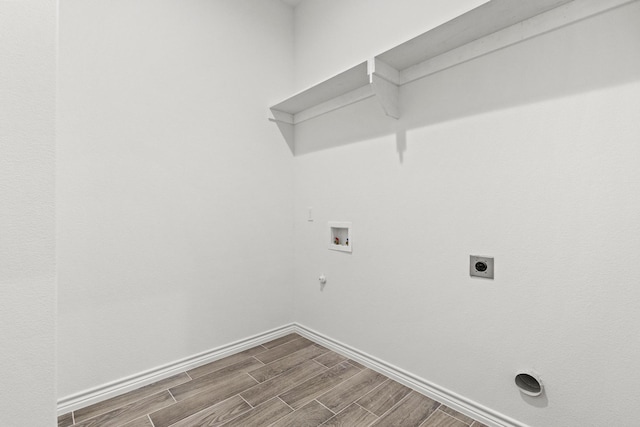 washroom featuring washer hookup, hookup for a gas dryer, baseboards, wood finish floors, and laundry area