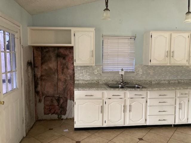 4220 Staghorn Cir N, Fort Worth, TX 76137 - kitchen featuring a sink, lofted ceiling, light tile patterned floors, tasteful backsplash, and pendant lighting