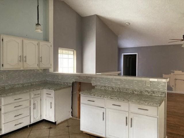 4220 Staghorn Cir N, Fort Worth, TX 76137 - kitchen featuring vaulted ceiling, backsplash, white cabinets, ceiling fan, and a textured ceiling
