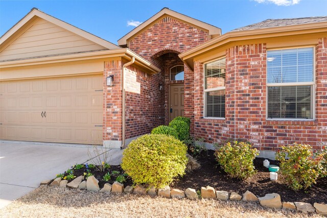 ranch-style house featuring an attached garage, brick siding, and concrete driveway
