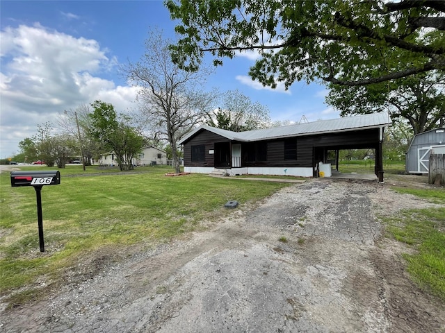 106 N 4th St, Celeste, TX 75423 - view of front facade with a carport, dirt driveway, a front lawn, an outbuilding, and metal roof