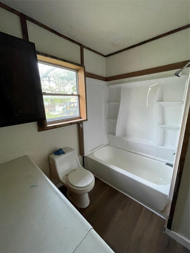 106 N 4th St, Celeste, TX 75423 - bathroom with toilet, shower / washtub combination, and wood finished floors