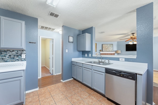 kitchen with dishwasher, a sink, light countertops, ceiling fan, and light tile patterned floors