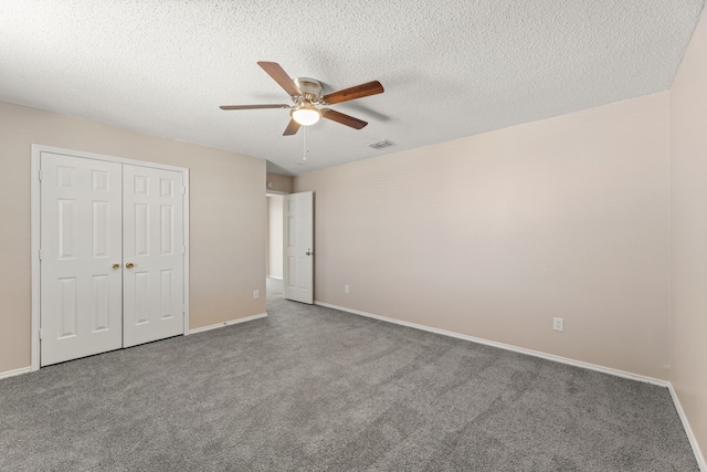 unfurnished bedroom with carpet floors, a closet, ceiling fan, baseboards, and a textured ceiling
