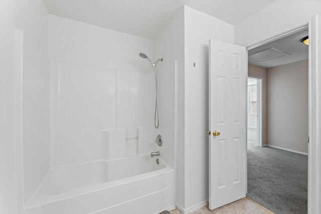 bathroom with a textured ceiling, shower / tub combination, and baseboards